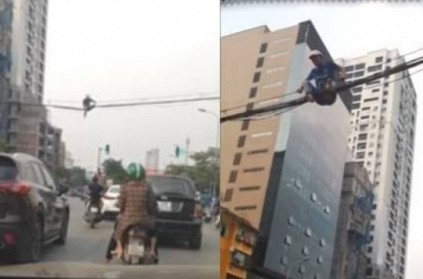 Watch - Vietnam man walks over power cables to cross road